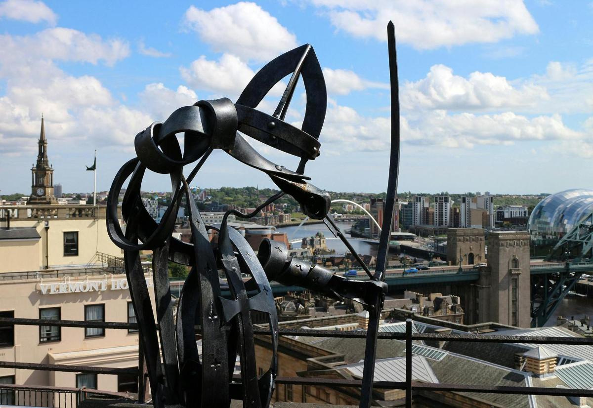 a statue of a pair of scissors on top of a building