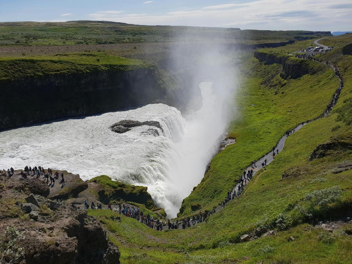 Un grupo de personas de pie al borde de una cascada.