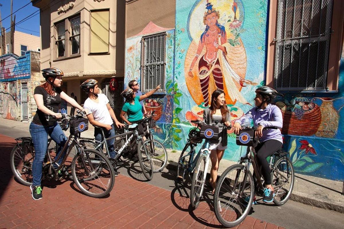 un gruppo di persone in bicicletta davanti a un murale