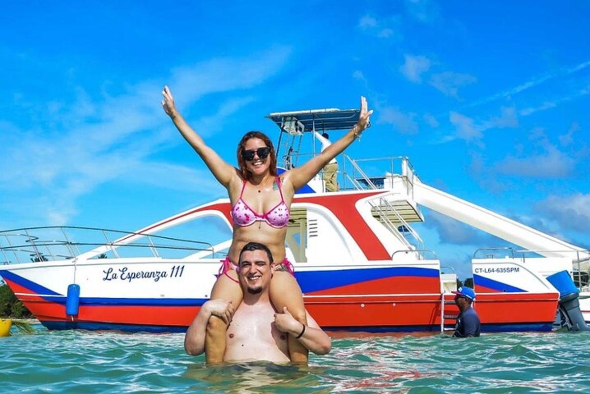 a man and woman in the water in front of a boat