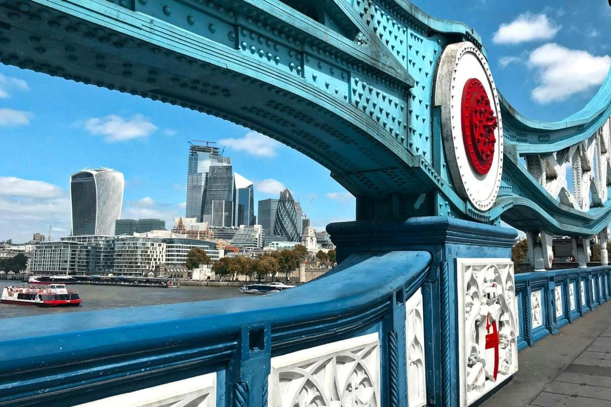 a blue bridge with a city in the background