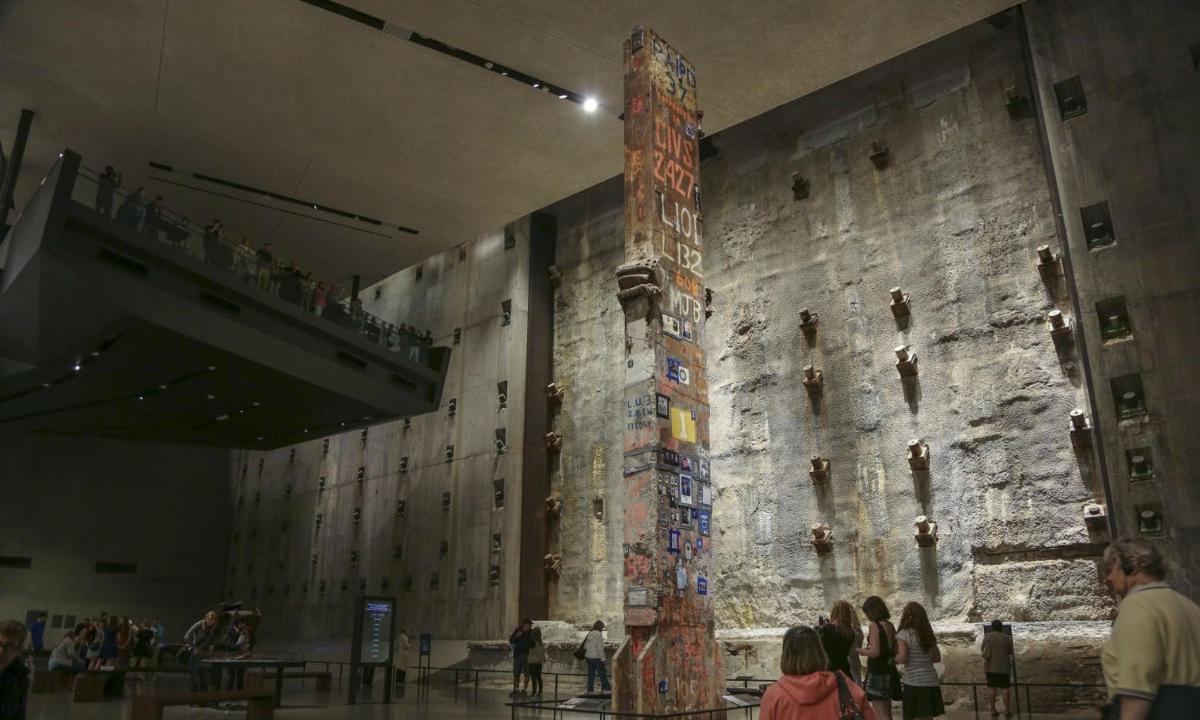 a group of people in a museum with a totem pole