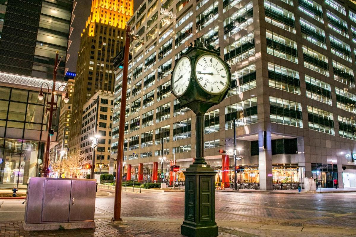 a clock on a pole in a city at night