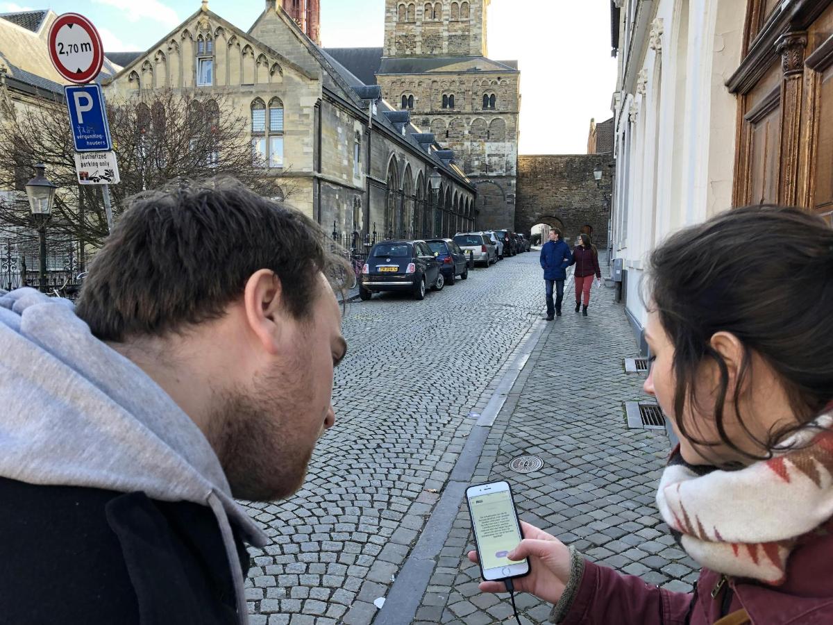 un uomo e una donna guardano un cellulare per strada