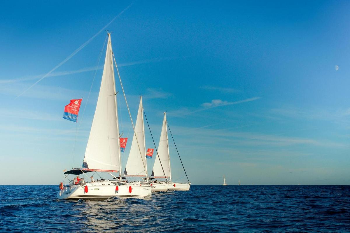 tři bílé plachetnice v oceánu na vodě