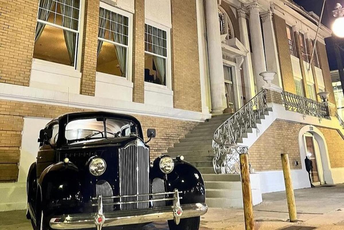 una vecchia macchina nera parcheggiata davanti a un edificio