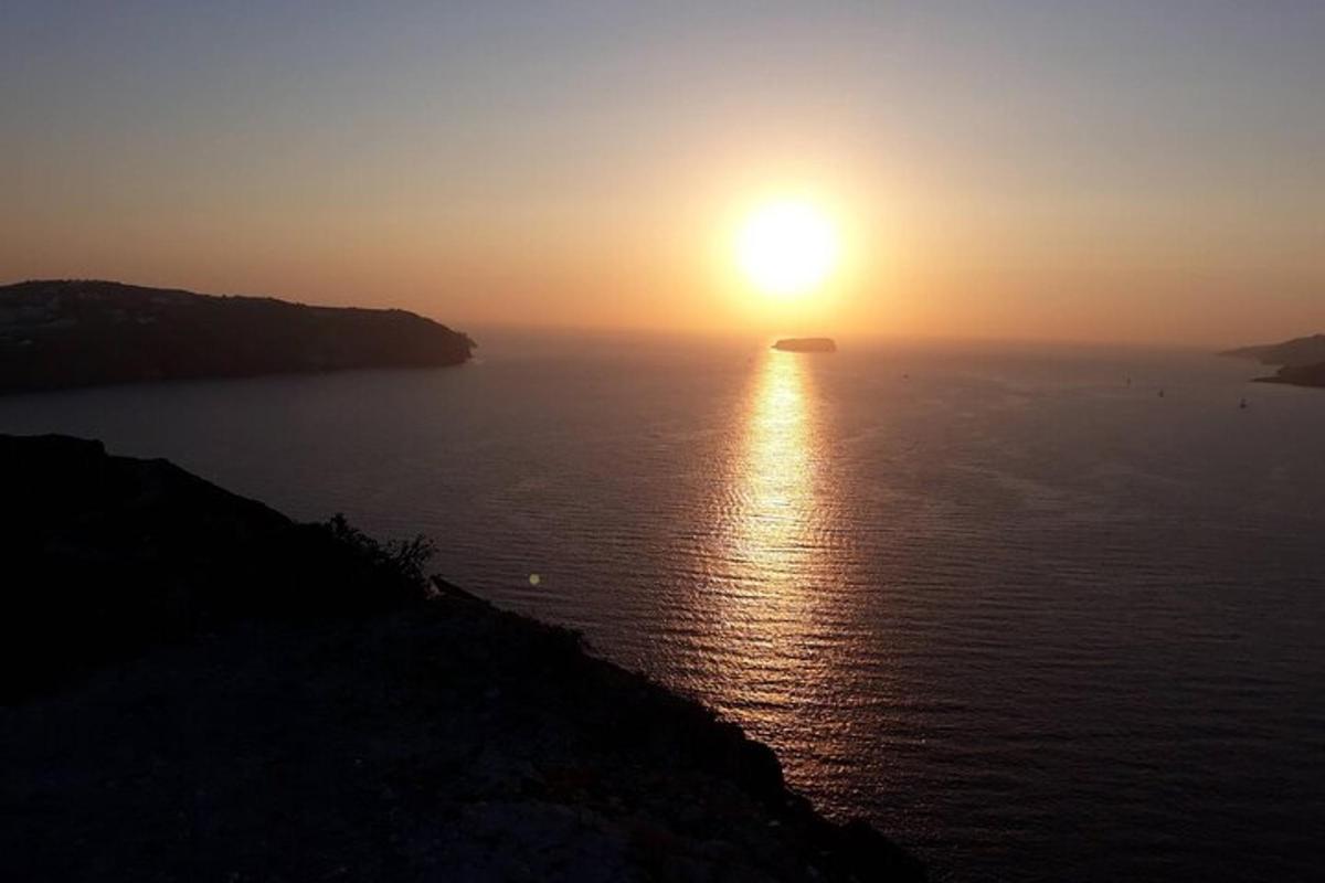 un tramonto su uno specchio d'acqua con un'isola