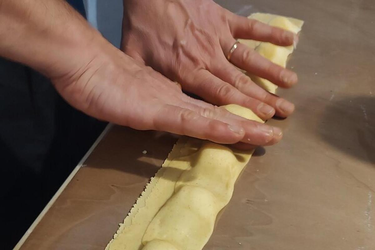 una persona que sostiene un trozo de masa sobre una mesa