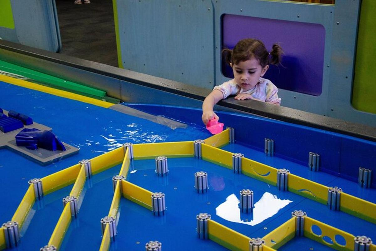a little girl playing with a toy in a pool