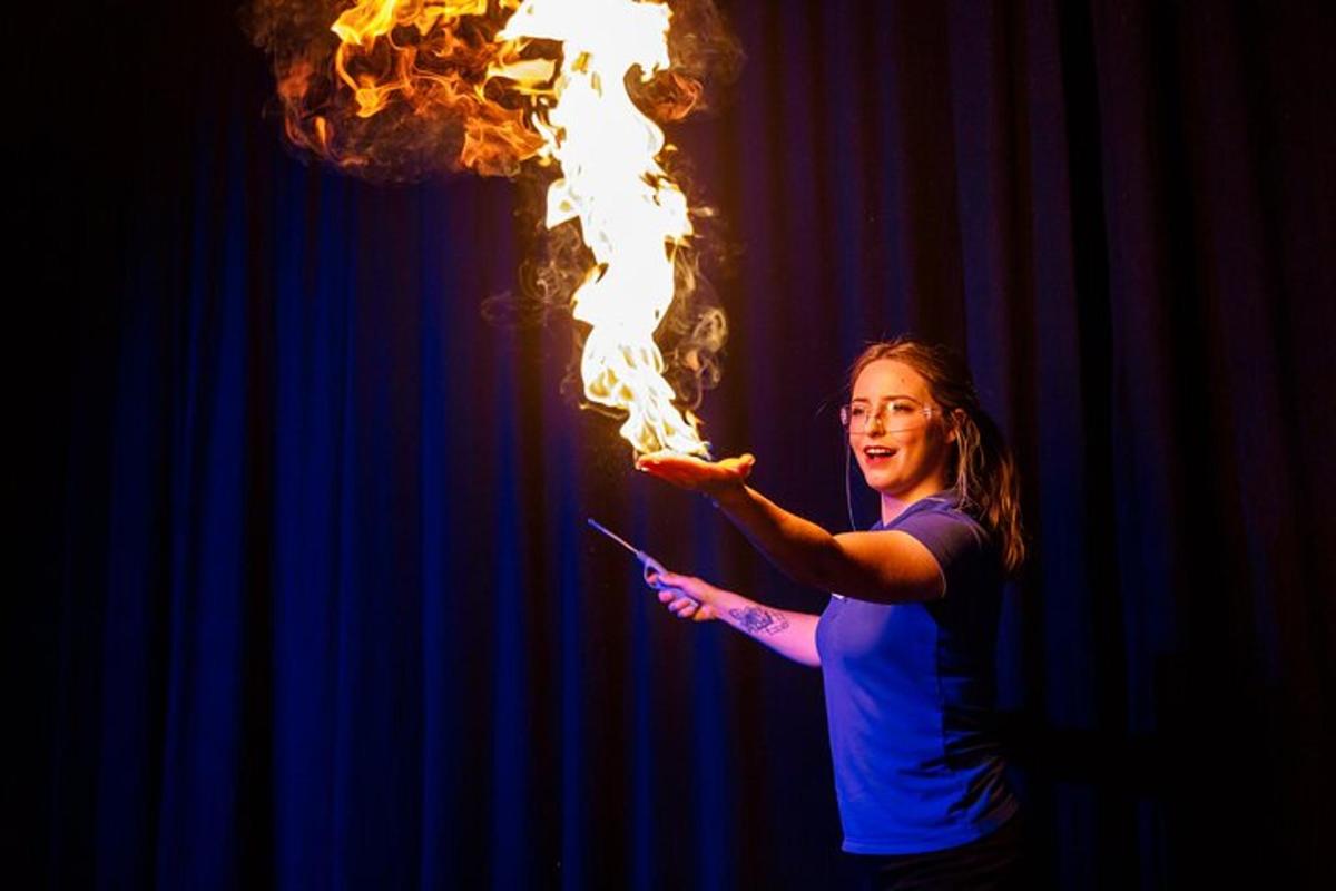 a woman holding a cell phone with fire in her hand