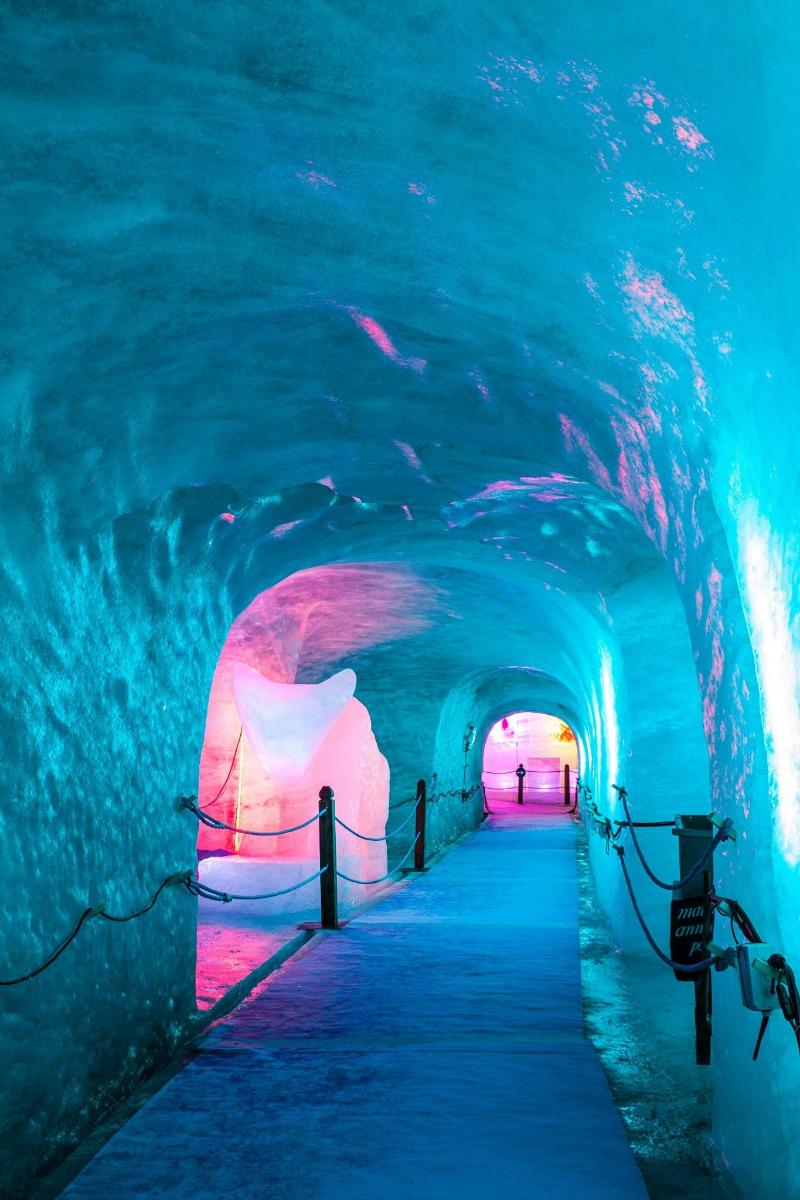 tunel ledové jeskyně s lidmi, kteří jím procházejí