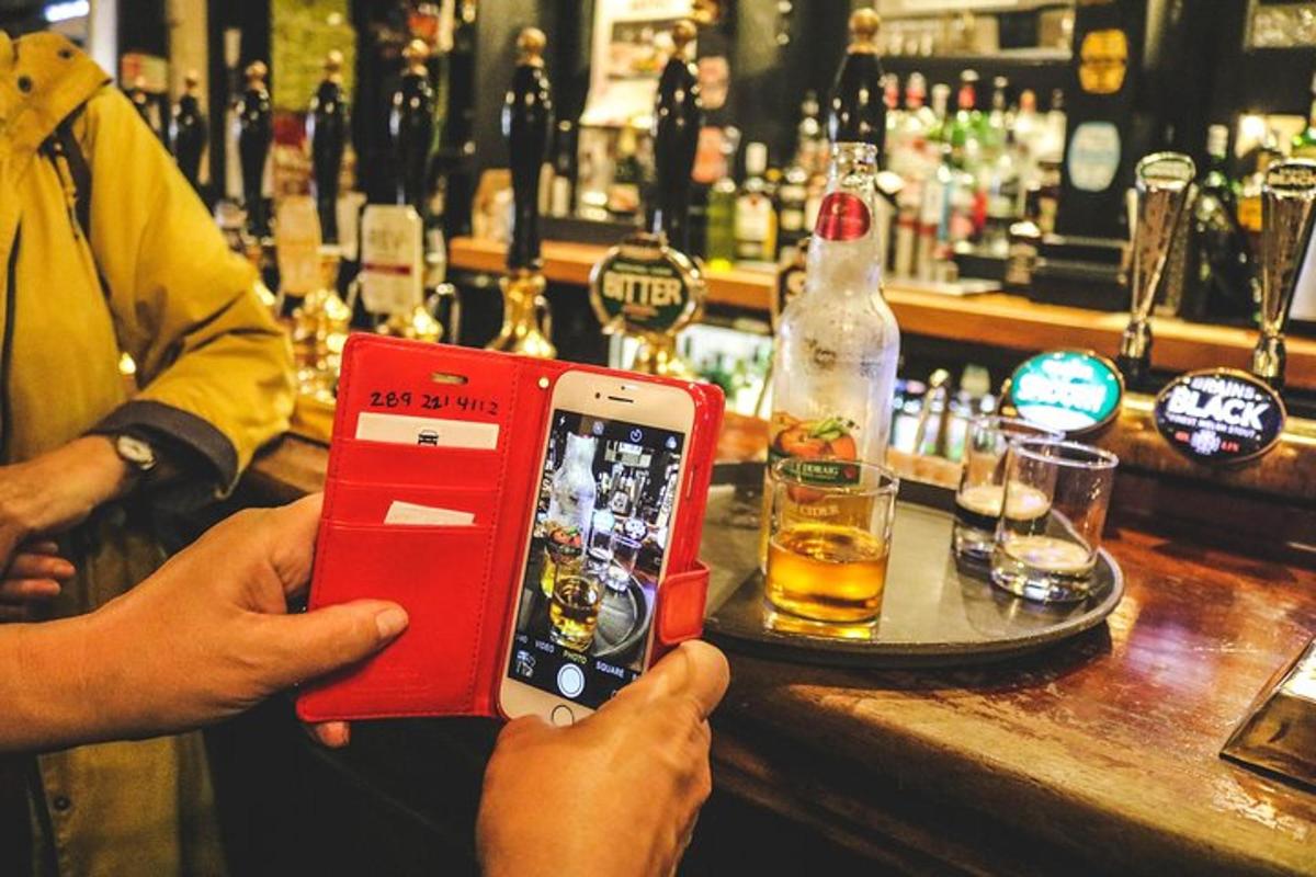 osoba fotící bar červeným mobilním telefonem