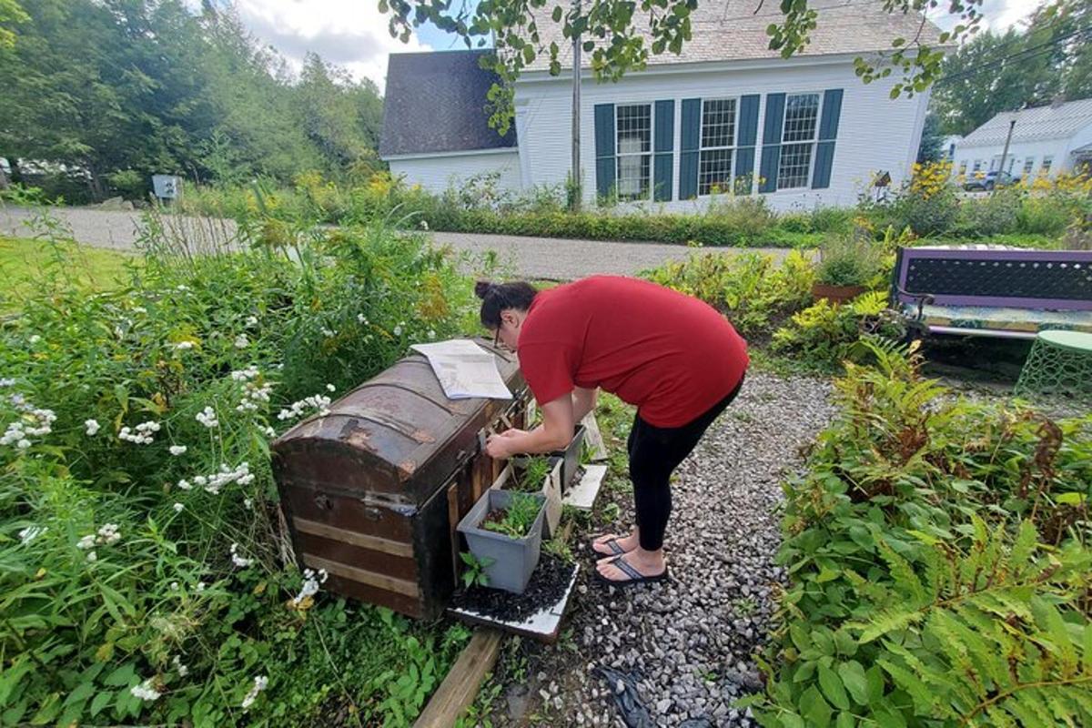 a person bending over a box in a yard