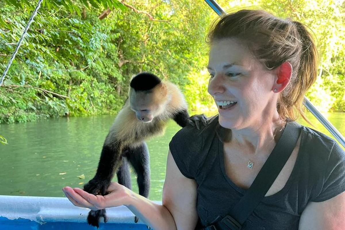 una donna su una barca con una scimmia sul braccio