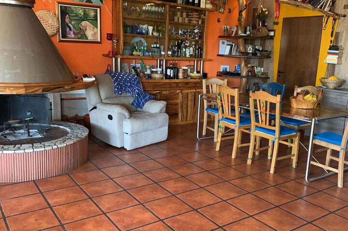 uma sala de estar com lareira, mesa e cadeiras