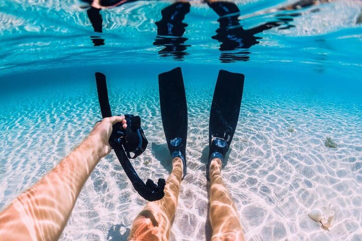 eine Person mit Skiern, die ihre Füße im Wasser haben