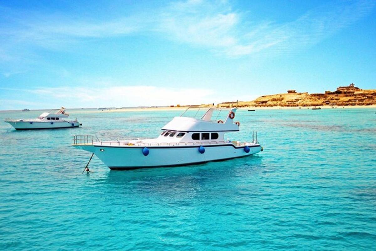 zwei Boote schwimmen im Wasser in der Nähe eines Strandes