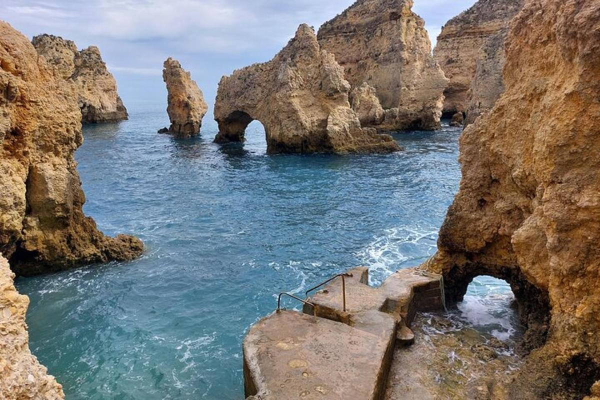 a staircase leading into the ocean between two rocks