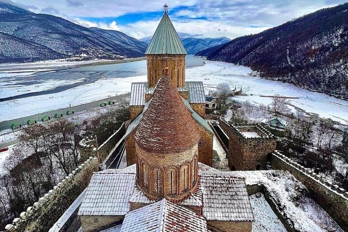 un edificio con un tetto verde con neve sopra