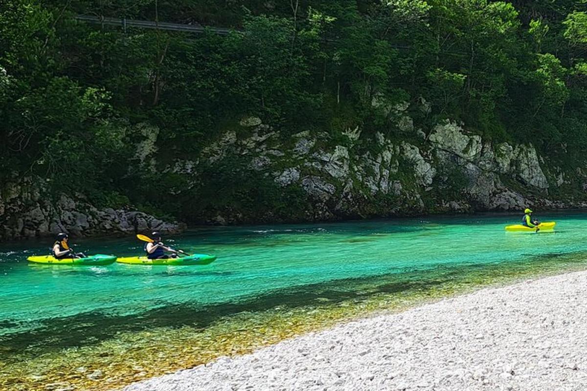 three people in kayaks in the water on a beach