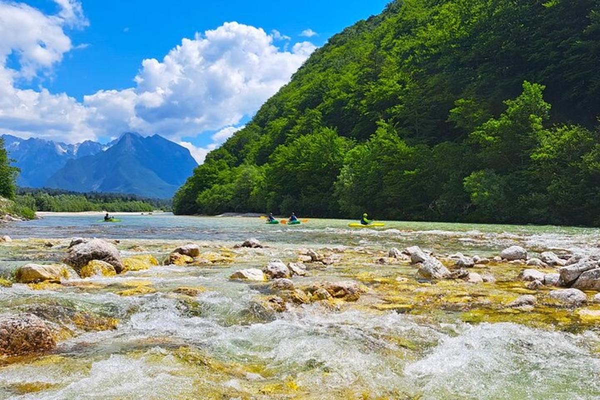 a group of people kayaking on a river in the mountains