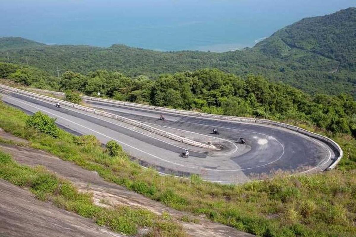 una strada tortuosa con persone che vanno in bicicletta