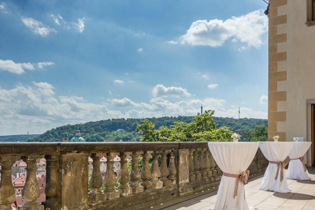balkon se stolem a bílými závěsy