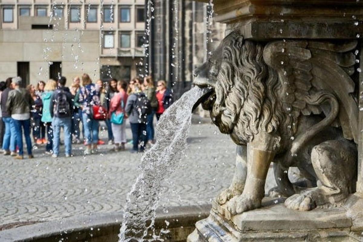 a fountain with a lion drinking water from it