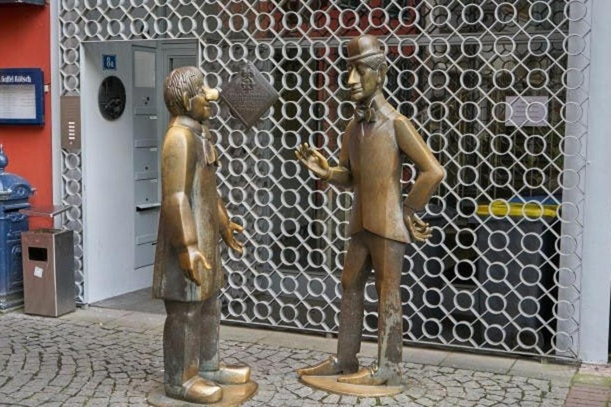 two bronze statues of a man and a boy on a street