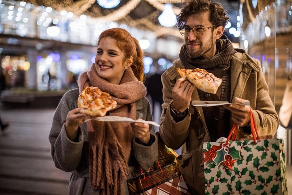 muž a žena držící dva kusy pizzy