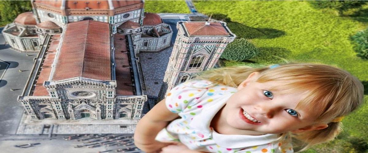 a little girl is standing in front of a castle