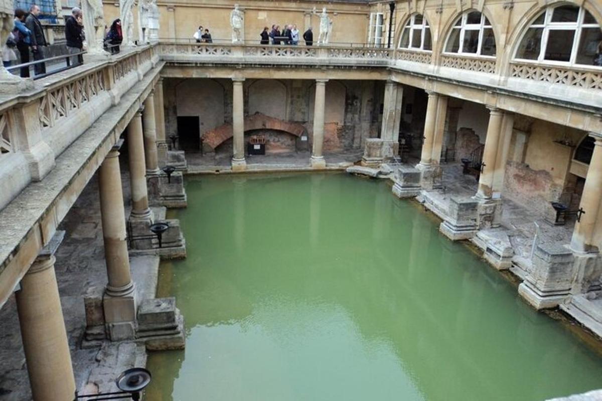 Un estanque de agua verde en un edificio con columnas.