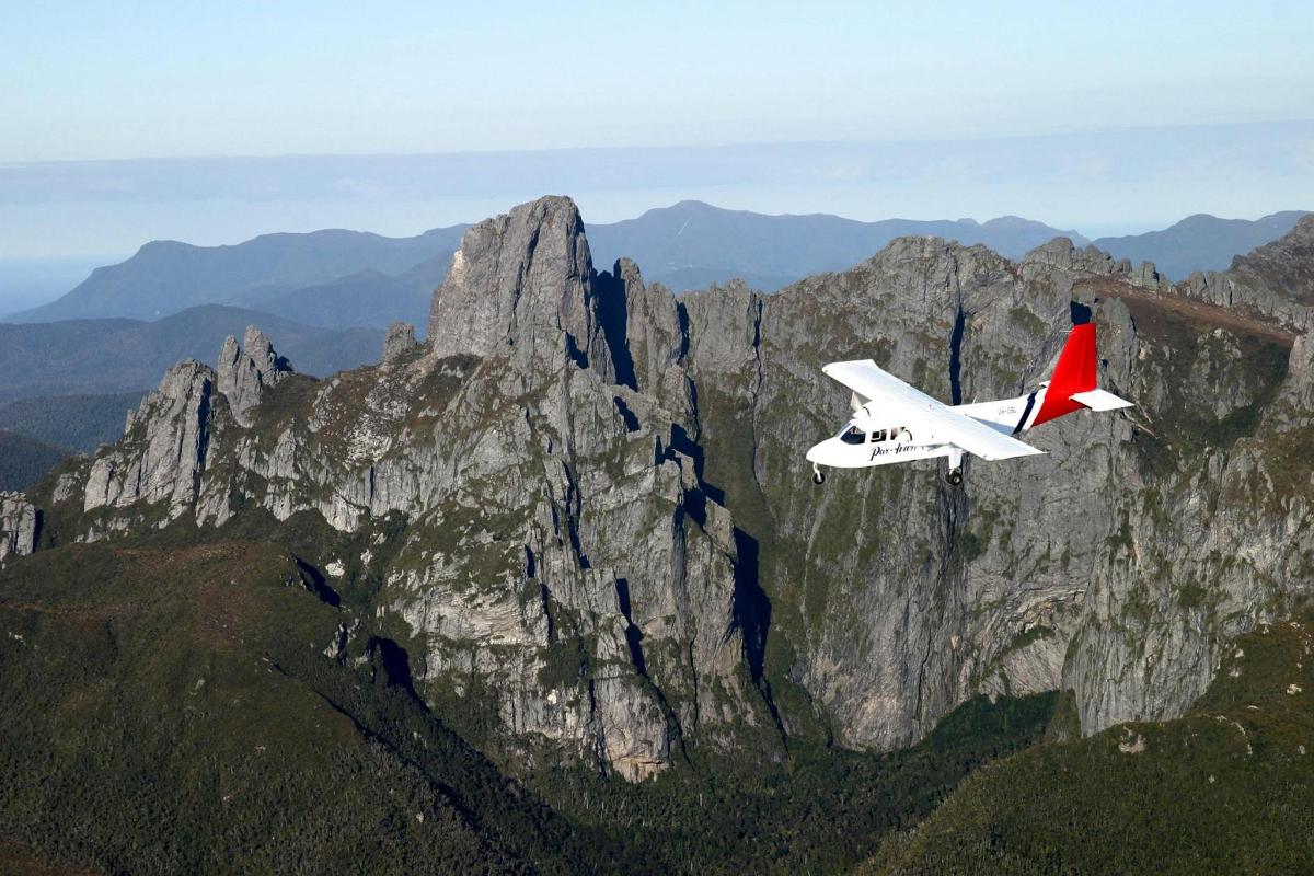 ein kleines Flugzeug, das vor einem Berg fliegt