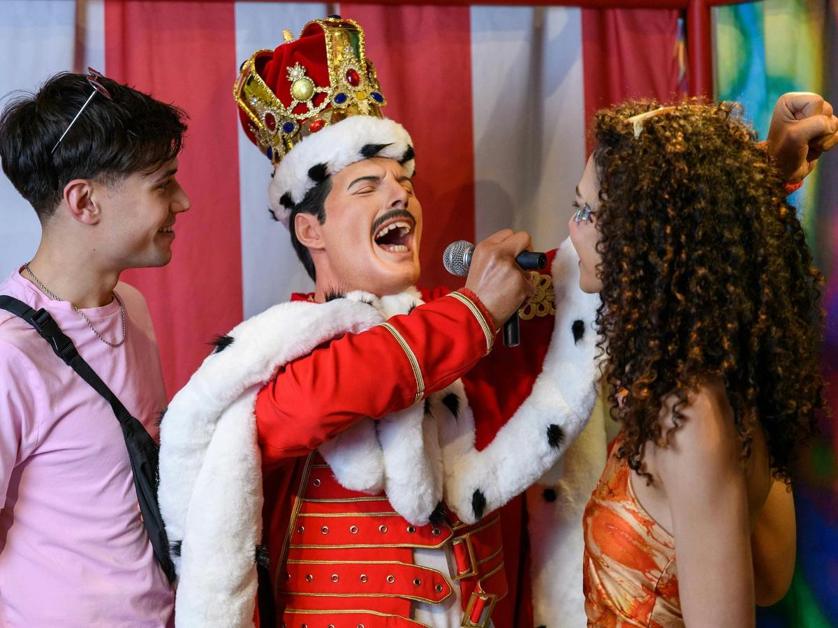 a man singing into a microphone next to a woman