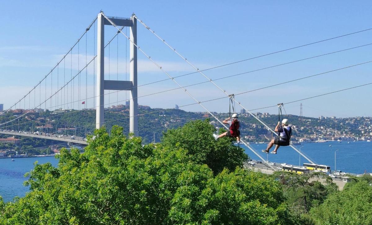 two people are walking across a suspension bridge