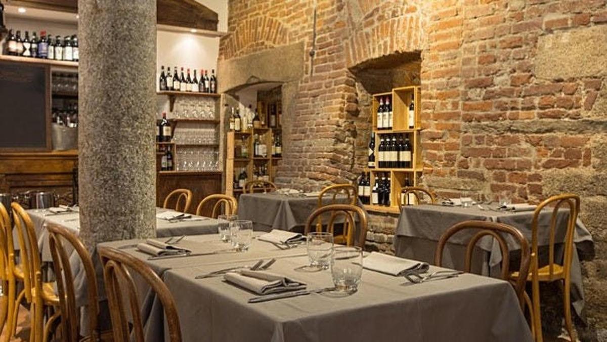 een restaurant met tafels en stoelen en een bakstenen muur