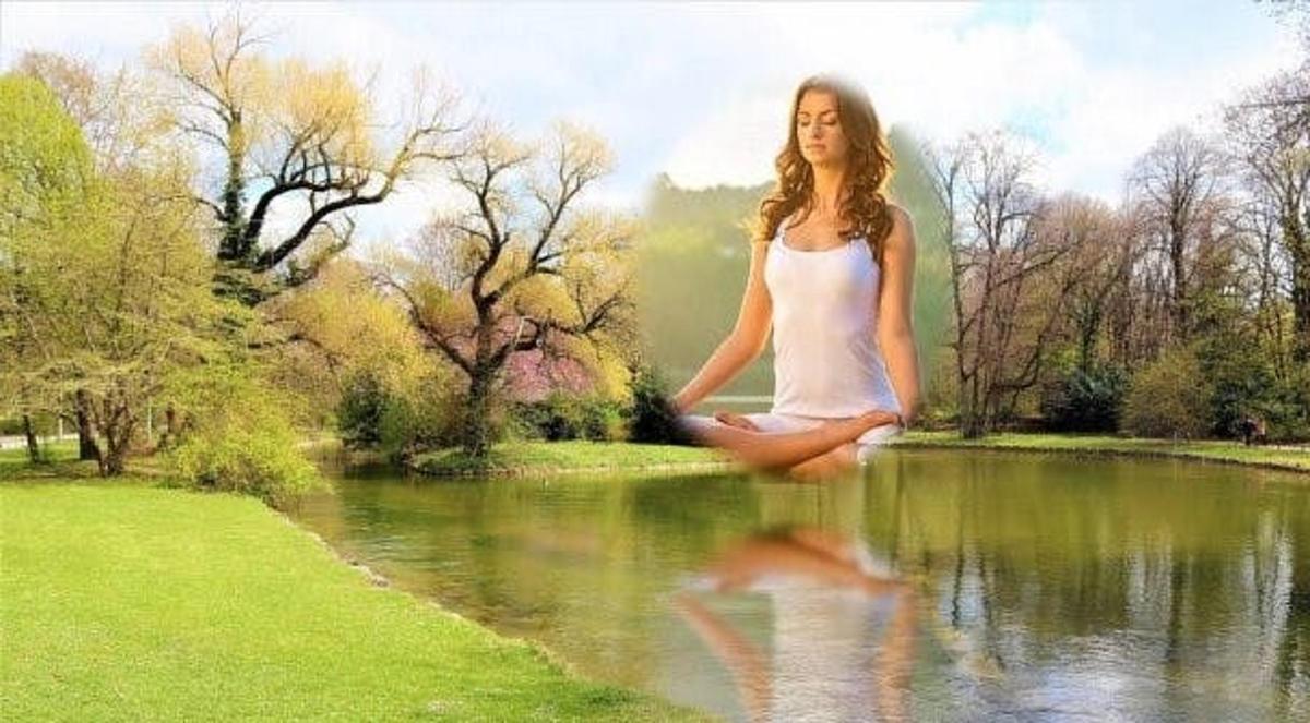 a woman sitting on the water in front of a pond