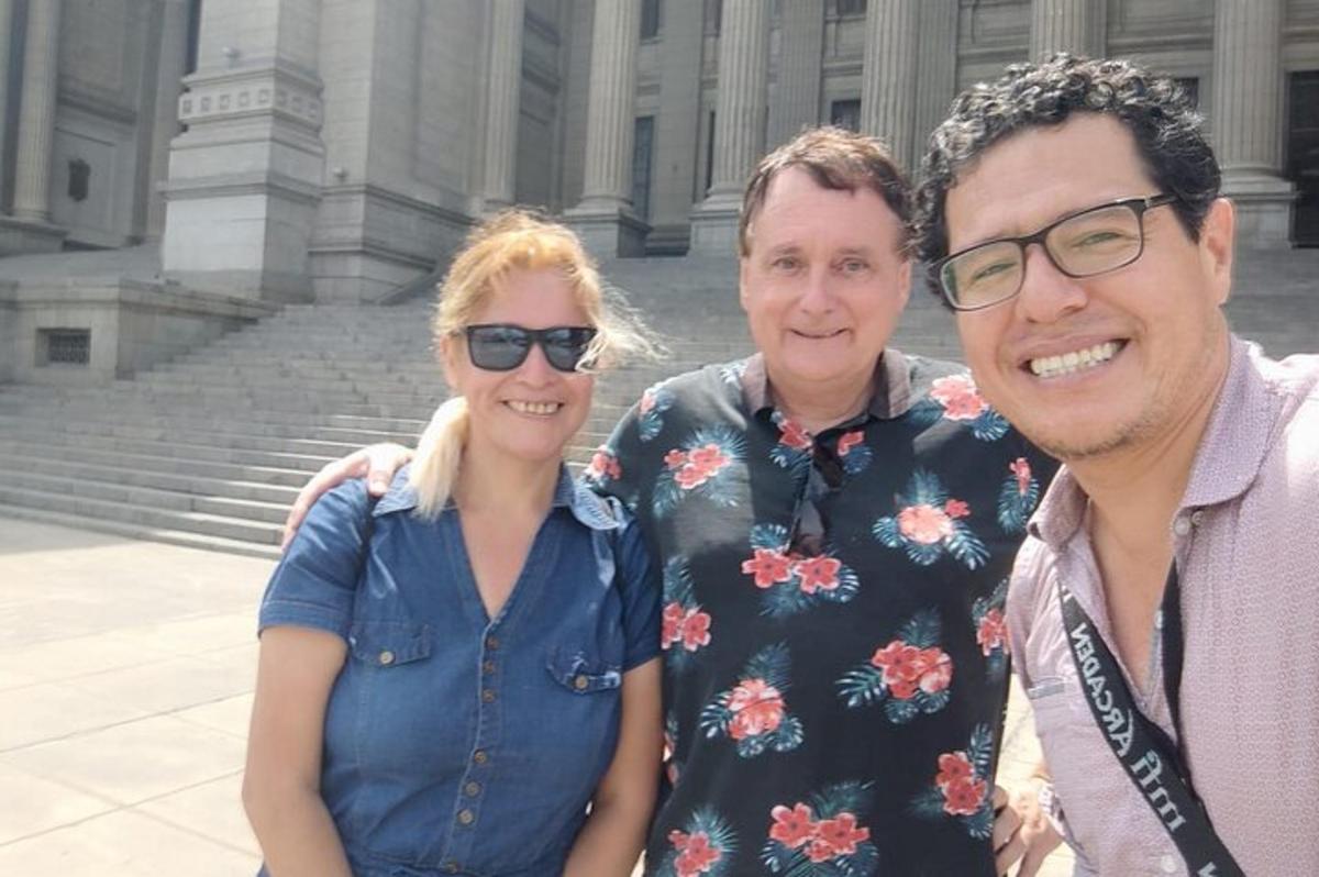 two men and a woman standing in front of a building