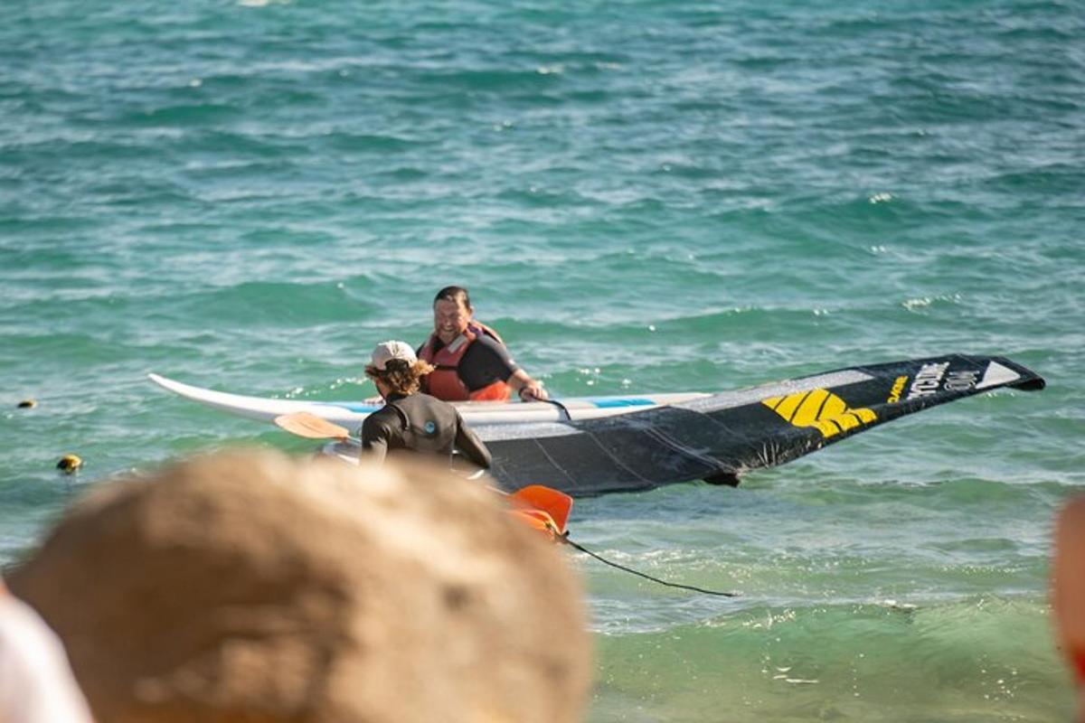 dva lidé v oceánu se surfovacím prknem ve vodě