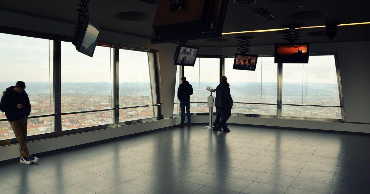 skupina ljudi, ki stojijo v stavbi in gledajo na mesto