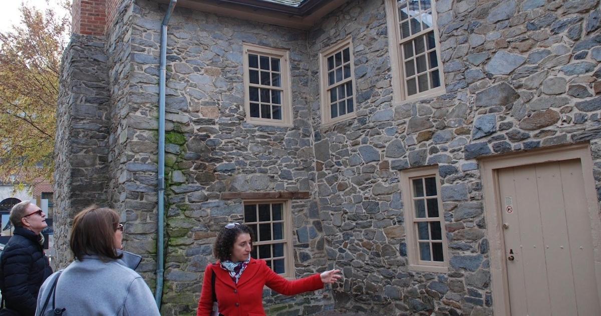 Un grupo de personas de pie frente a un edificio de piedra.
