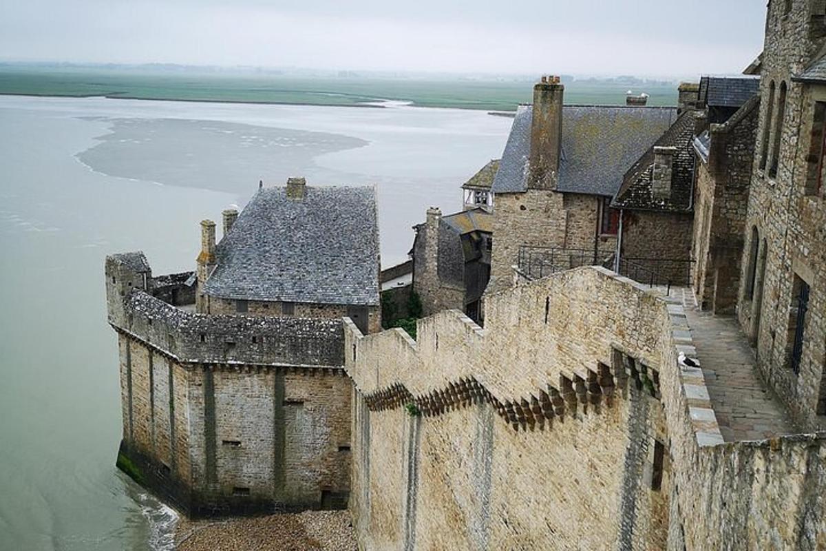 an aerial view of a castle next to a body of water