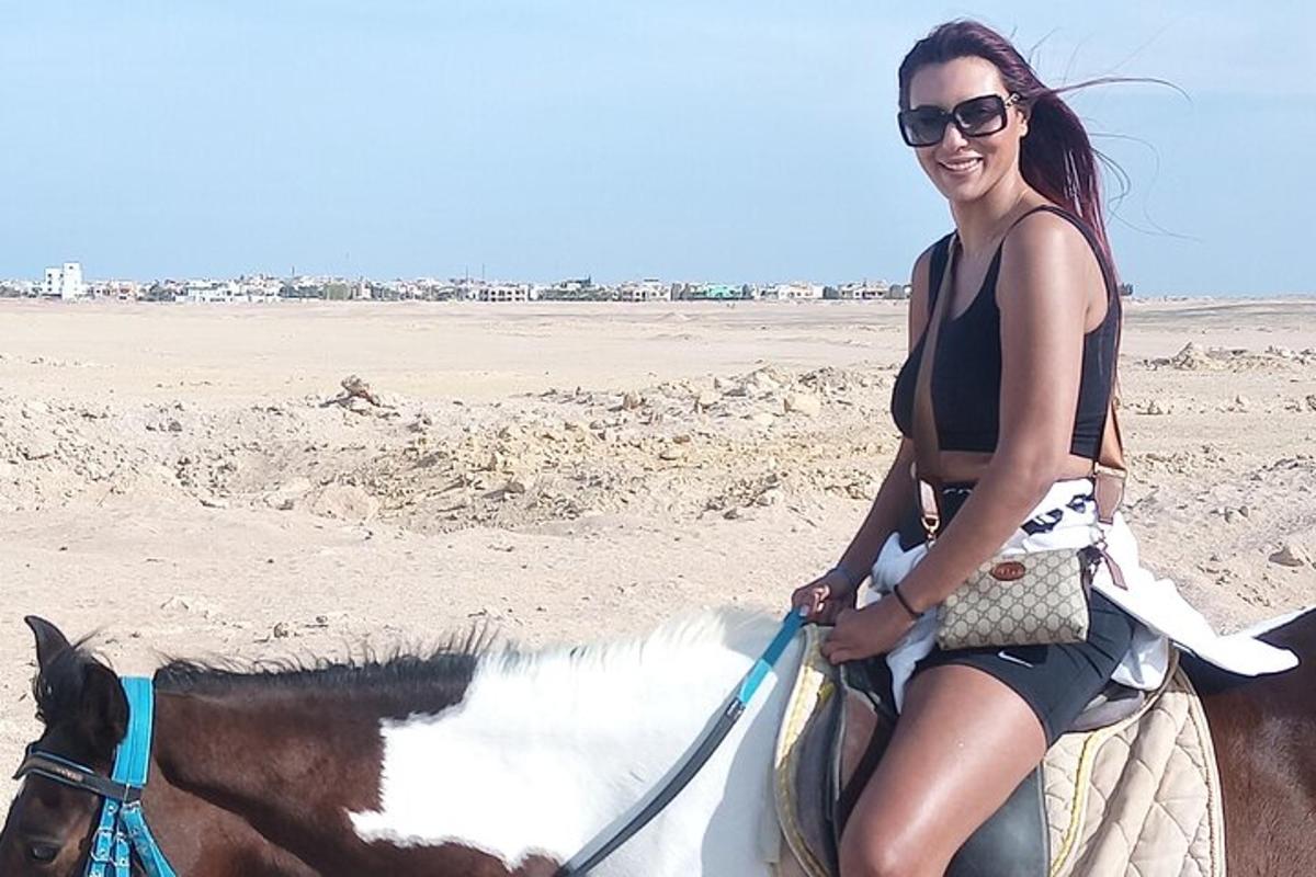 una donna a cavallo sulla spiaggia