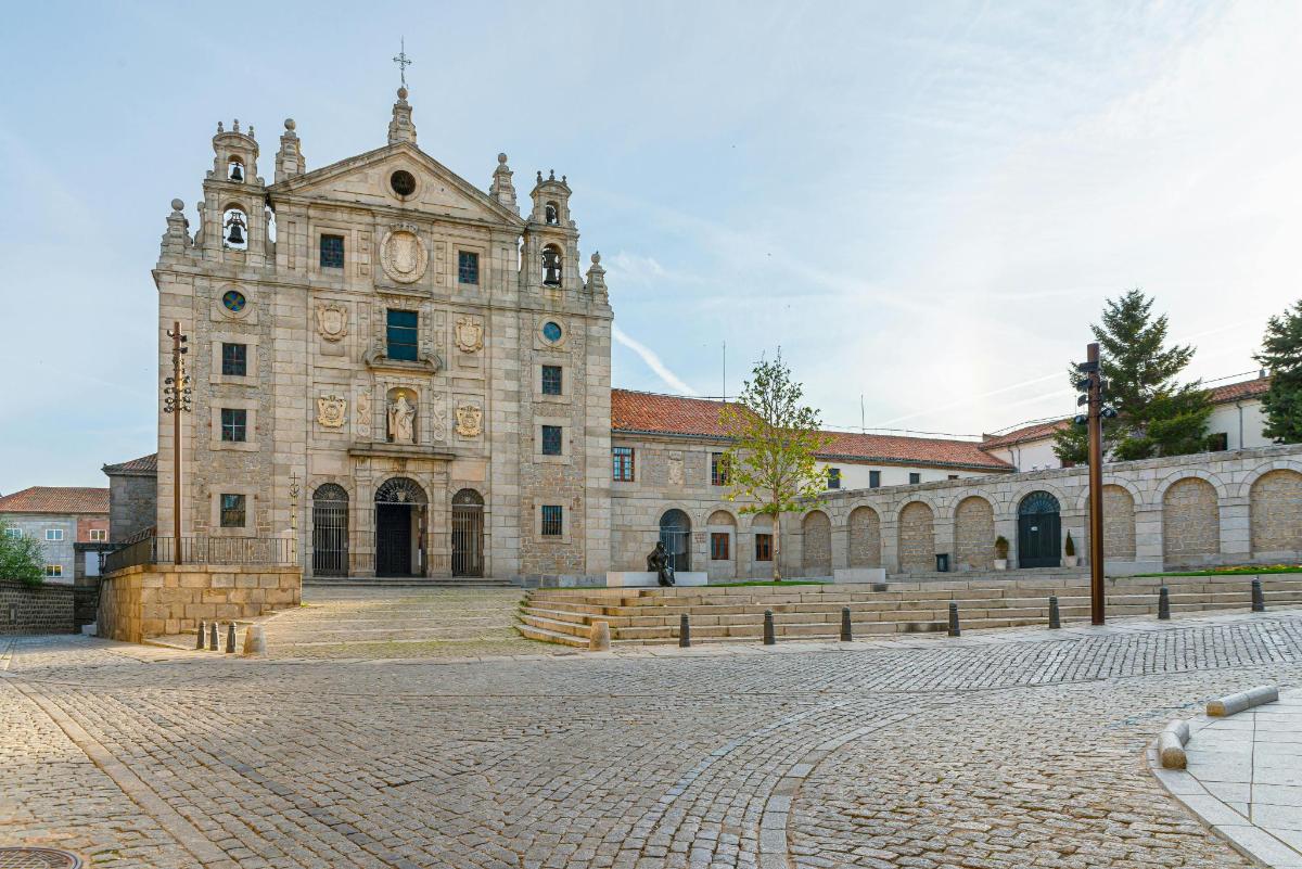 an old stone building with benches in front of it