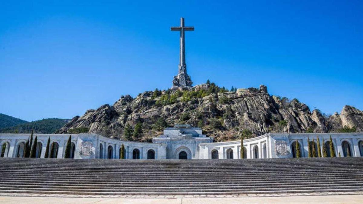 una chiesa con una croce in cima a una montagna