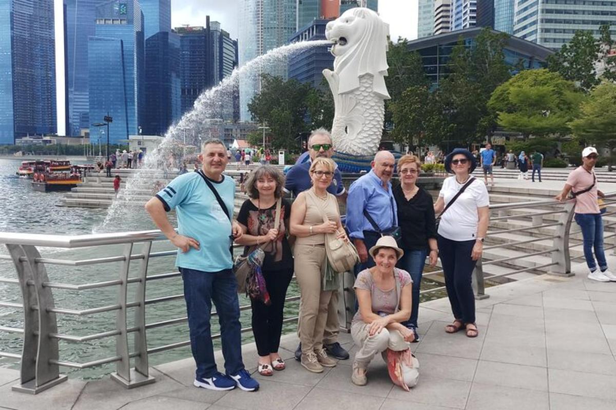 Un grupo de personas de pie frente a una fuente.