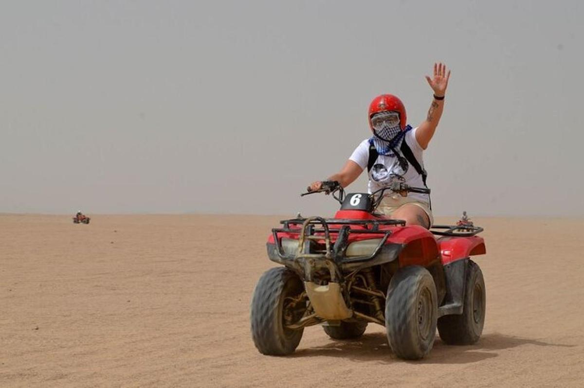 un home muntant un quad al desert