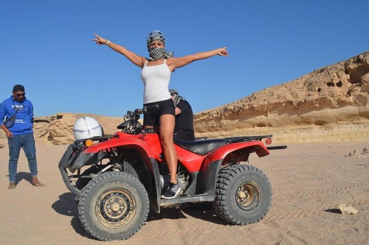 una dona asseguda en un quad al desert