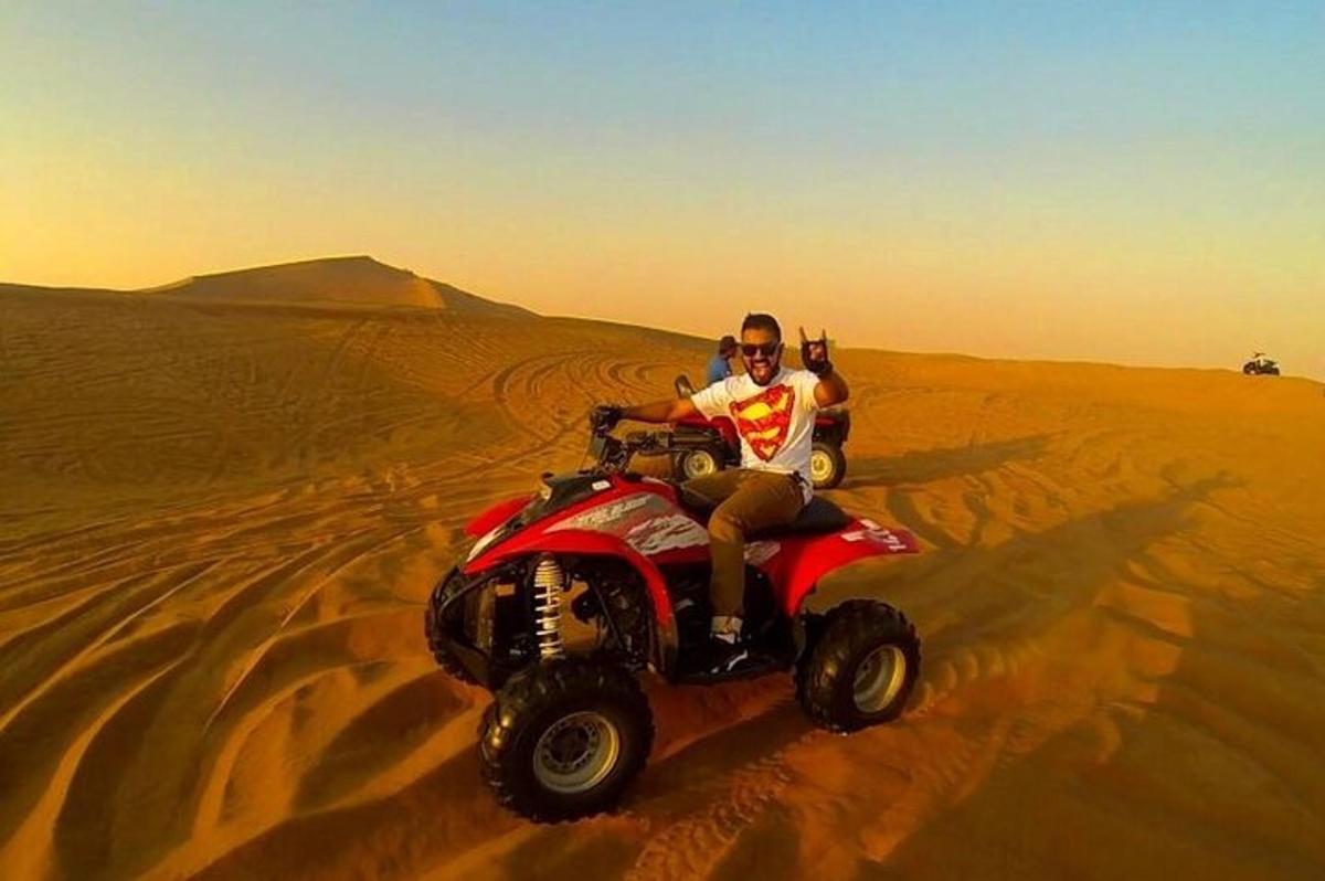un home que condueix un quad al desert