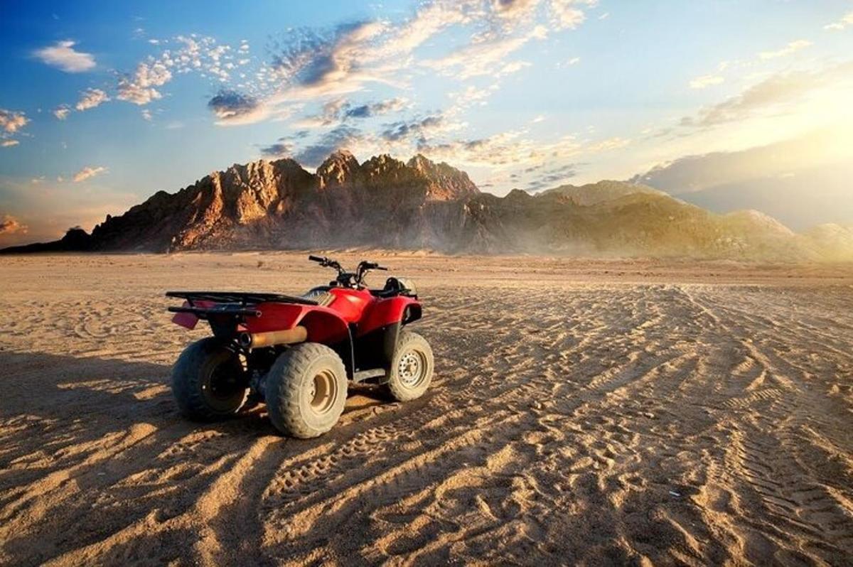 un quad vermell aparcat a la sorra del desert